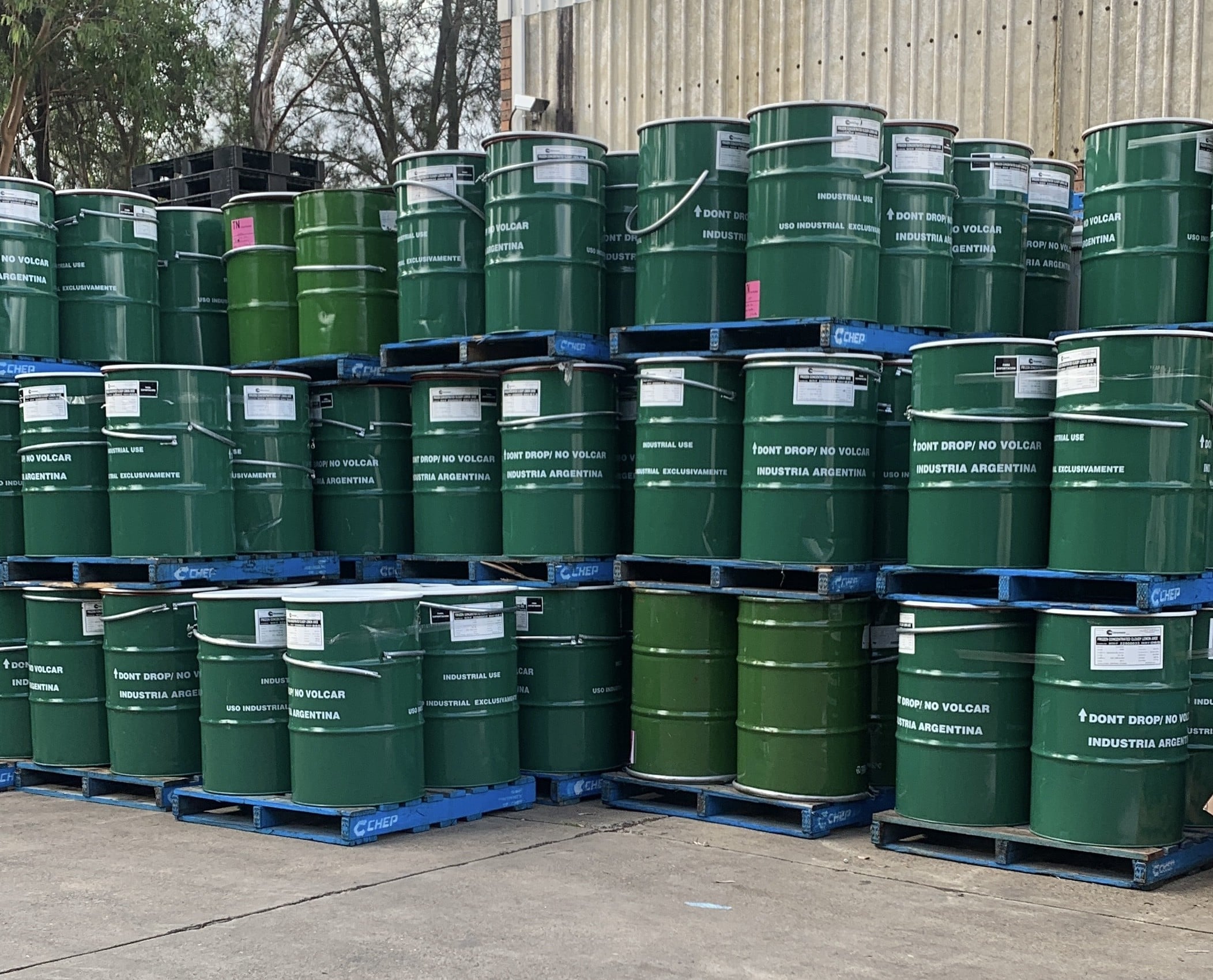 Manufacturing customer bulk fill metal drums with food product for shipping transport.
